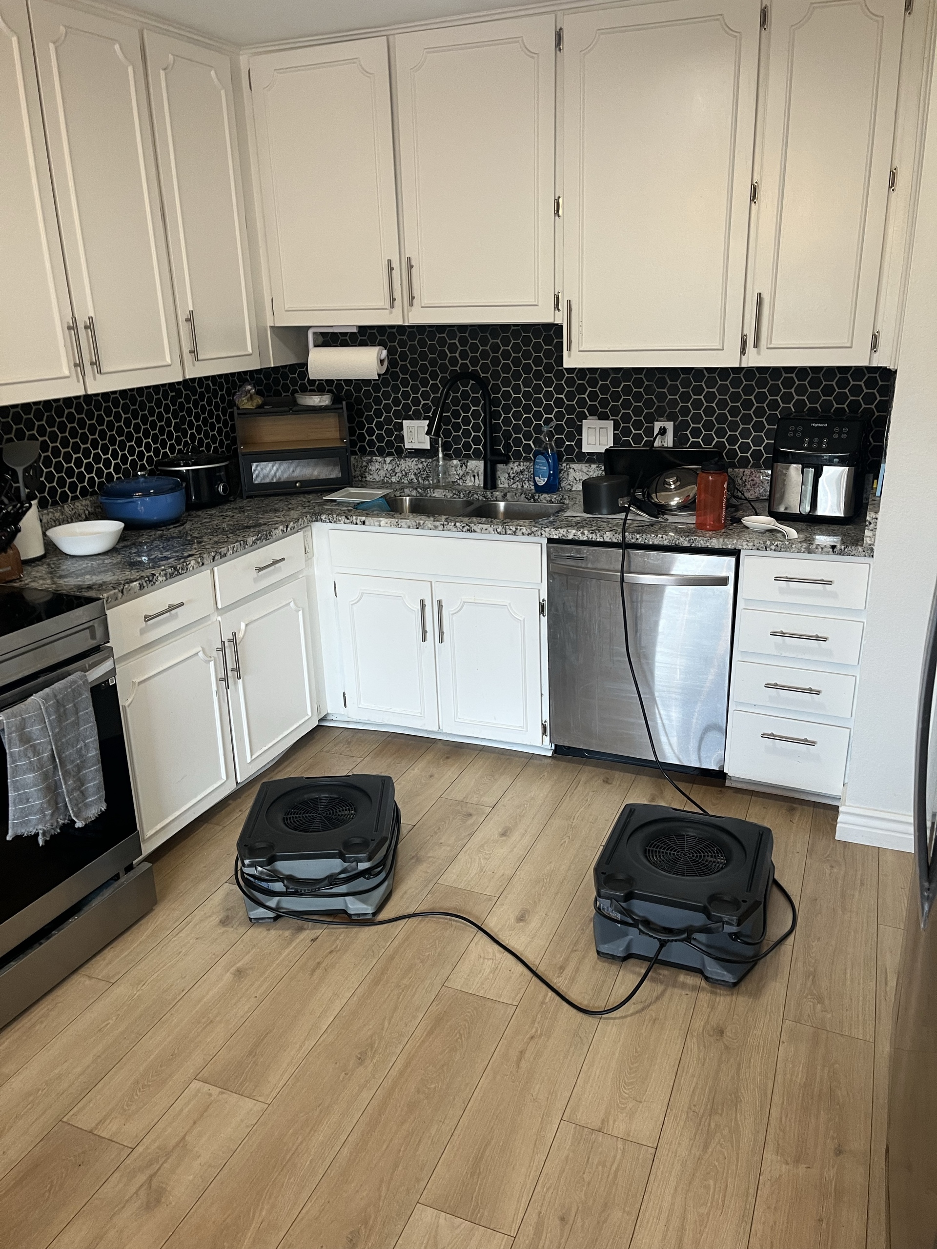 Bathroom strip-out with industrial air movers and dehumidifiers running